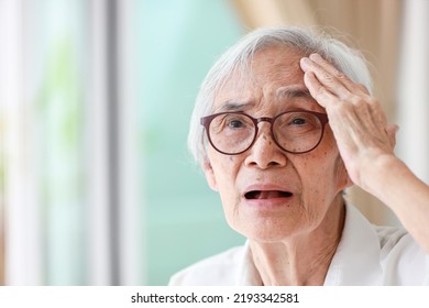 Forgetful asian senior woman with amnesia,brain disease,patient holding head with her hand,suffering from senile dementia,memory disorders,confused old elderly with Alzheimer's disease,health problems