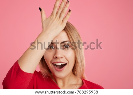 Forgetful female model remembers something after long time, keeps hand on forehead, opens mouth in surprisment, remembers to buy present for friends on coming holidays. Bad memory concept