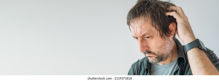 Forgetfulness concept, guy scratching his head trying to remember something, panoramic image with copy space - Shutterstock ID 2119371818