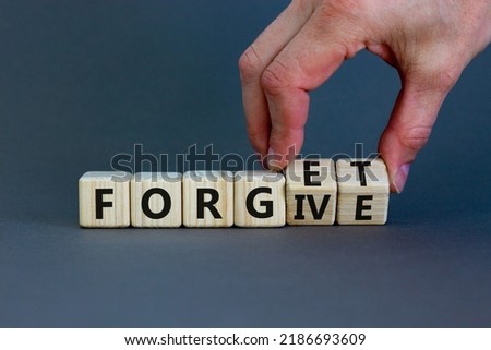 Forgive and forget symbol. Businessman turns wooden cubes and changes the word 'forgive' to 'forget'. Beautiful grey background, copy space. Business, psychological forgive and forget concept.