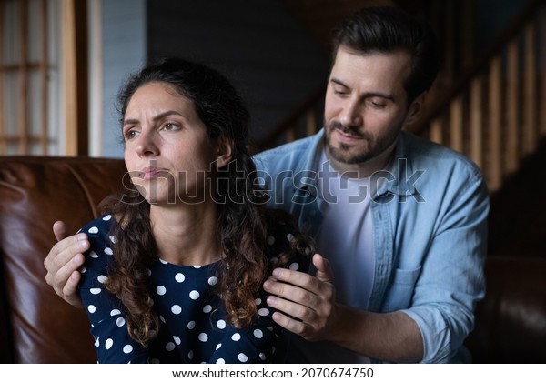Forgive me please. Guilty young husband hug\
shoulder of offended wife ask forgiveness apologize after quarrel\
conflict fight. Millennial man try to make peace with stubborn\
sulky woman admit his\
fault