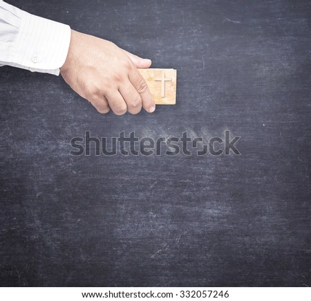 Forgiven sin  concept: Some text being erased from a chalk board by christian with eraser of cross