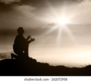 Forgiveness Concept: Silhouette Prayer Kneeling And Praying To God Over Supernatural Light Autumn Background