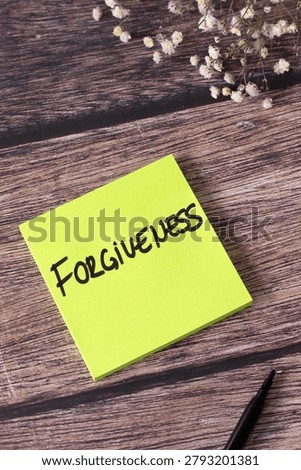 Forgiveness, handwritten text note on wooden background. Top view. Christian biblical concept.