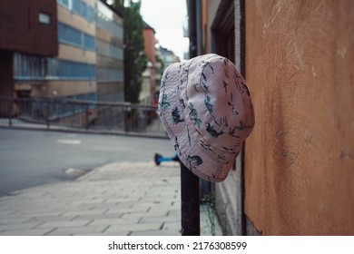 Forgotten baby hat hanging on pole in city
