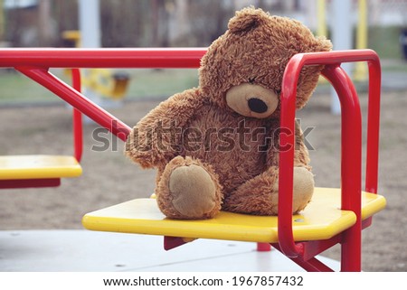 Forgotten Brown Plush Bear on a Childrens Carousel in an Empty Playground. Concept of Childhood, Growing up