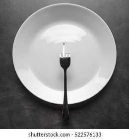 Fork Bent In The Shape Of Obscene Gesture Middle Finger Sign Lies On An Empty Plate Instead Of Food