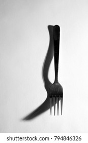 Fork isolated with creative shadow, black and white