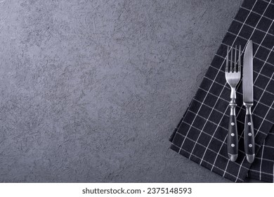 Fork and knife with dark handle. Tableware. Top view, copy space