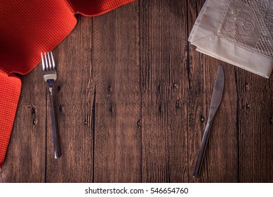 Fork And Knife On Wooden Table With Kitchen Towel.Top View