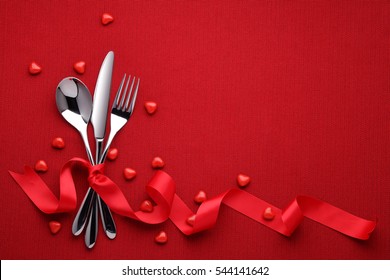 Fork Knife Spoon With Ribbon On Red