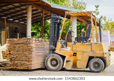 Fork lifter loaded with construction material plank framework at the building site