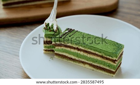 Fork lifting matcha cake bite presented in a detailed culinary, dessert, or fresh food setting.