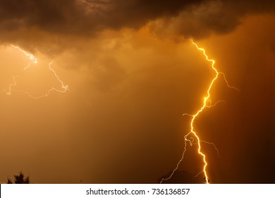 Fork Lightning Over Dark Orange Sky On Stormy Day.