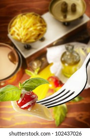 Fork with macaroni tomatoes and basil
