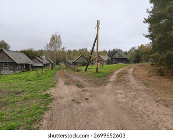 A fork in the road between two paths in an old village with wooden houses made of logs