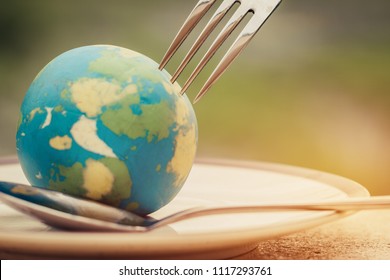 Fork slammed on Globe model placed on plate  for serve menu in famous hotel. International cuisine is practiced around the world often associated with specific region country. World food inter concept