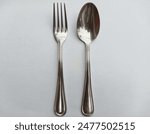 Fork and spoon isolated on white background, top view, flat lay