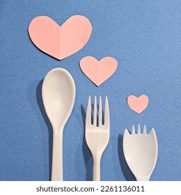 A fork, spoon, and spork together on a blue background symbolizing family and love