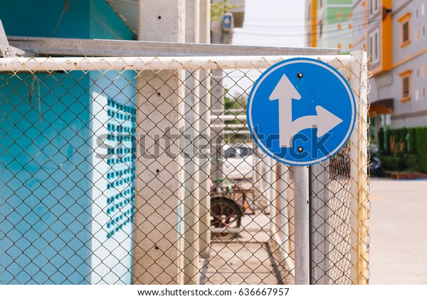 Forked road blue warning sign on street background,\
Right Turn Split, road\
sign