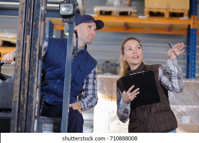 Forklift Driver And Female Supervisor With Clipboard