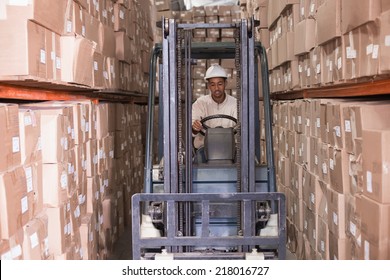 Forklift driver operating the machine in a large warehouse