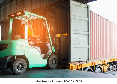 Forklift Driver Unloading Cargo Shipment Into A Truck Trailer.