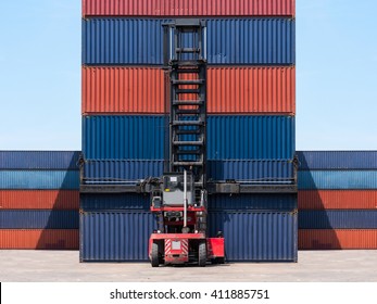 Forklift Handling Cargo Shipping Container Box In Logistic Shipping Yard With Cargo Container Stack In Background