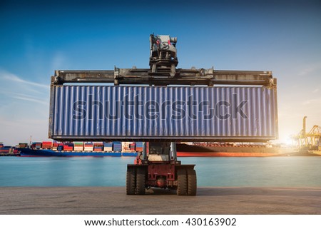 Forklift handling container box loading at port cargo at sunset