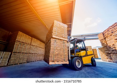 Forklift loader load lumber into a dry kiln. Wood drying in containers. Industrial concept
