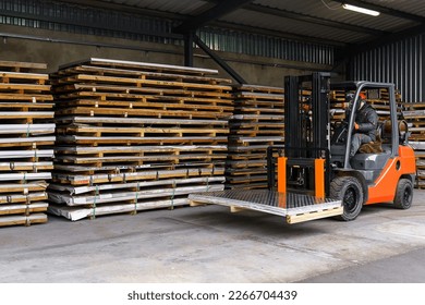 Forklift loader in the metal warehouse. Loading and unloading stainless steel sheets - Powered by Shutterstock