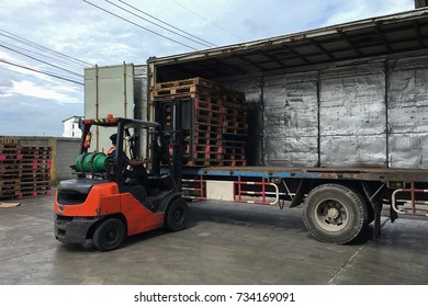 Forklift loader works outdoors loading (unloading) a long lorry truck