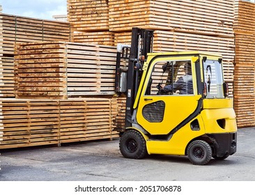 Forklift loads lumber into stacks at the finished product warehouse - Shutterstock ID 2051706878