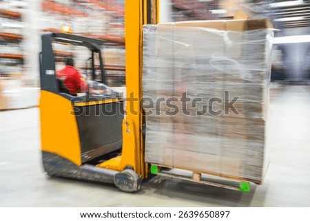 Forklift operator transporting large package on pallet in busy warehouse, emphasizing speed and efficiency in logistics operations