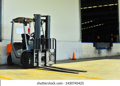 Forklift Is Parked In Front Of The Warehouse.