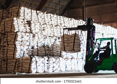 Forklift stacking up sugar bag inside warehouse, sugar warehouse operation. Agriculture product storing and logistics for import and export.