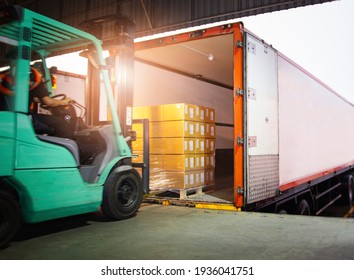 Forklift Tractor Loading Package Boxes on Pallet into Cargo Container. TrailerTruck Parked Loading at Dock Warehouse. Shipment Delivery. Supply Chain. Shipping Logistics Freight Truck Transportation. - Shutterstock ID 1936041751