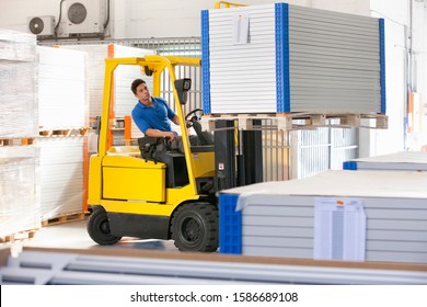 Forklift Truck Driver Stacking Solar Panels In Factory Warehouse