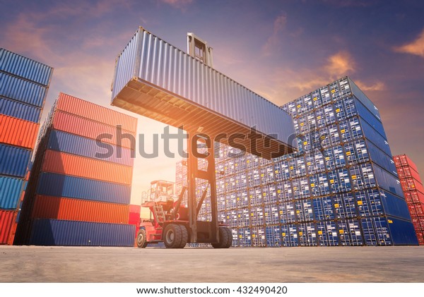 Forklift\
truck handling cargo shipping container box in logistic shipping\
yard with cargo container stack in\
background