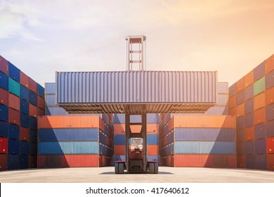 Forklift Truck Lifting Cargo Container In Shipping Yard For Transportation Import,export, Logistic Industrial With Container Stack In Background