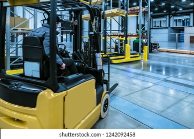 Forklift Yellow. Warehouse Automation. Boxes Are On The Shelves Of The Warehouse. Warehousing. Logistics In Stock. Forklift Rides Through The Warehouse.