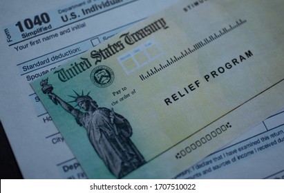 Form 1040 U.S. Individual Income tax return next to the Stimulus Check Relief program. Close up view.  - Shutterstock ID 1707510022