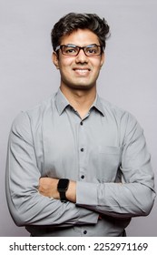 Formal business male portrait. Confident successful Indian businessman or manager, in shirt, stands in the studio background with arms crossed, looks directly at camera and smiles friendly. - Shutterstock ID 2252971169