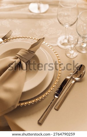 A formal dining table is set with fine china, silverware, and glassware, ready for a special occasion