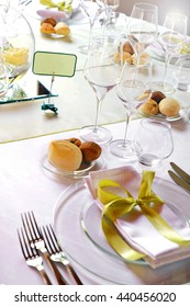 Formal Luxury Table Setting For A Catered Event With Linen, Dinnerware And Glasses Decorated With Gold Bows And Place Names, Close Up View On One Place Setting