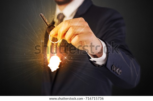 Formal\
man hand over shiny keys with dark\
background\
