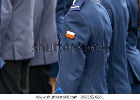 formal uniform with a Polish flag patch on the sleeve during an official ceremony.
