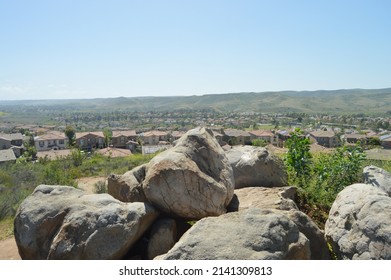 Formation Of Rocks Overlooking The Suburbia Below