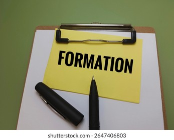 Formation Text on Yellow Note Clipped on Clipboard with Black Pen Representing Business Formation, Startup Planning, Company Establishment, Legal Registration, and Strategic Development Concept. 
