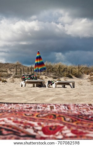 Similar – Colorful striped, closed parasol in close-up on the beach at sunset